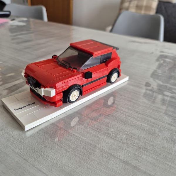 Red brick hatchback model with light wheels on a white display base